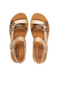 Sandali in pelle tan con cinturini regolabili, suola in sughero e accenti metallici. Il design comprende cinturini incrociati nella parte anteriore.