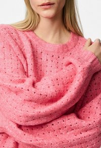 Maglione rosa lavorato a maglia con vestibilità oversize, caratterizzato da un motivo testurizzato e polsini a coste. Materiale morbido con dettagli a punto aperto visibili.