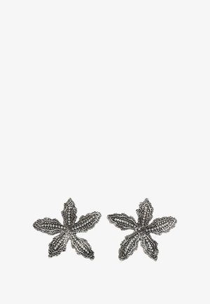 Silver floral earrings feature an intricate, lace-like design with five petals, embellished with small, clear stones for added detail.