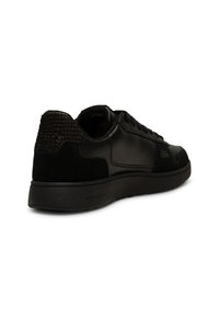 Crne tenisice od kože i antilopa, s teksturiranim petama, zaobljenim oblikom te vezanjem i ravnim gumennim potplatom.