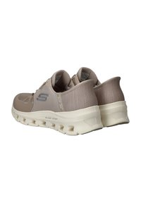 Beige Sport Schuhe mit einem strukturierten Mesh-Obermaterial und einer dicken weißen Sohle mit Ausschnitten. S-Logo an der Seite, entworfen für Komfort und Unterstützung.