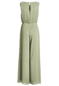 Combinaison sans manches vert clair à jambes larges, avec taille froncée et petite ouverture en forme de goutte d’eau à l’arrière du col avec fermeture par bouton.