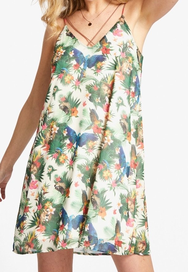 Robe midi à fleurs avec un fond clair, présentant des oiseaux tropicaux vibrants et des fleurs, des fines bretelles spaghetti, et une silhouette ample et fluide.
