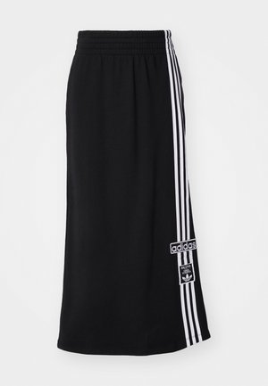 Falda deportiva negra con cinturilla elástica, que presenta tres rayas blancas a lo largo de un lado y un parche con el logo de Adidas. Textura de tela suave.