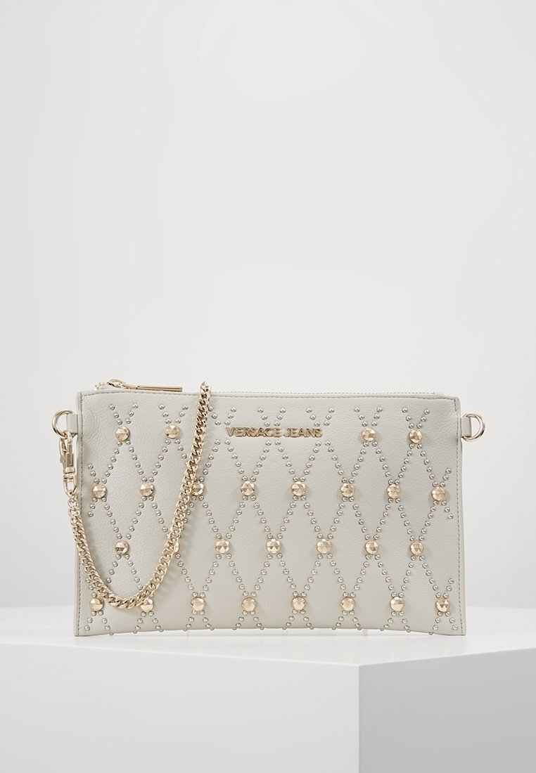 Sac à main matelassé gris avec ferrures en or et clous décoratifs. Comprend une bandoulière en chaîne détachable et un logo de marque embossé à l'avant.