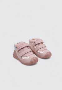 Chaussures pour tout-petits de couleur rose avec deux bandes Velcro, accents latéraux irisés et semelle texturée pour une bonne adhérence. Fabriquées en matériau synthétique léger.