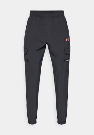 Czarne spodnie cargo wykonane z lekkiego materiału; posiadają elastyczny pas, boczne kieszenie oraz pomarańczowe logo Under Armour.