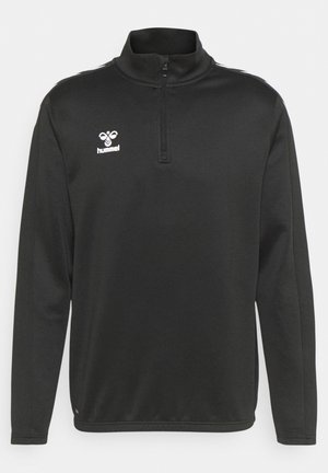 Sort langærmet sweatshirt med lynlåskrave, prydet med et hvidt logo på brystet og teksturerede sidekanter. Blødt, strækbart materiale.