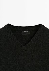 Ciemnoszary wełniany sweter w serek z prążkowanym kołnierzem. Prosty wzór, gładka faktura, a metka z napisem "Massimo Dutti" i "100% Wełna."