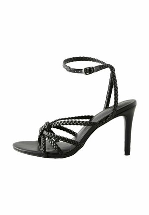 Sandalette nera con tacco alto, dotata di cinture intrecciate e di una cinghia alla caviglia regolabile. Texture liscia con punta affusolata e tacco a stiletto di 10 cm.