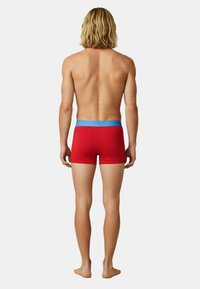 Red men's boxer briefs with a blue elastic waistband, featuring a close-fitting design and smooth, stretchable fabric.