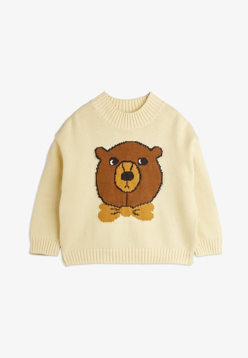 Κρεμ μπλούζα από πλεκτό ύφασμα με γραφικό καφέ αρκούδας που φοράει παπιγιόν. Ριμπ σακάκι και μανσέτες. Μαλακό, υφασματοποιημένο ύφασμα.