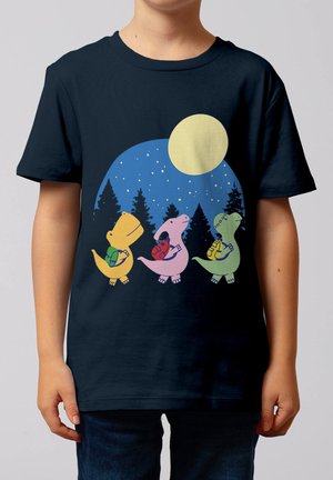Drei bunte Comic-Dinosaurier mit Rucksäcken gehen in einem Wald unter einem sternenklaren Nachthimmel und Vollmond auf einem dunkelblauen T-Shirt spazieren.
