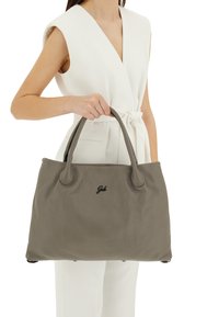 Borsa tote in pelle grigia con una texture a ciottoli, dotata di due manici arrotondati e di un logo discreto. Il design è spazioso e strutturato.