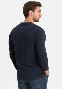 Marineblauw langarm T-shirt van katoen, met een ronde hals en aansluitende mouwen, met een gladde textuur en een subtiele glans.