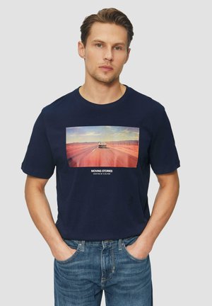 Dunkelblaues T-Shirt mit kurzen Ärmeln, das ein zentrales Grafikmotiv eines Autos auf einer Straße zeigt, mit dem Text "BEWEGTE GESCHICHTEN" unter dem Bild. Aus Baumwollmaterial.
