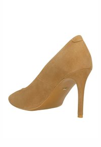 Béžová semišová lodička na vysokém podpatku s kulatou špičkou, hladkým povrchem a elegantním klínovým podpatkem, se slušným zlatým logem.