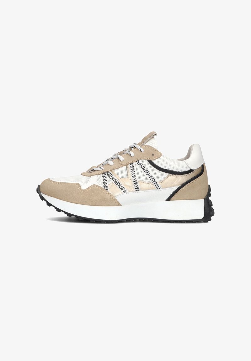 Beige en witte sneaker van suède en mesh materialen. Heeft contrasterende zwarte accenten, een vetersluiting en een dikke zwarte rubberen zool.
