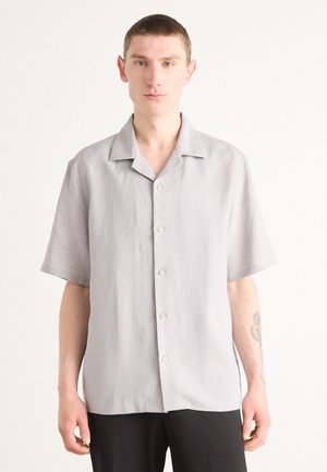 Short-sleeve shirt in light gray linen, featuring a button-up front, pointed collar, and a relaxed fit. Smooth texture and minimal design details.