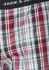 Kockás boxeralsó, piros, zöld, fekete és fehér kockás mintákkal. Gumis derékpánt, fehér "JACK & JONES" logóval.