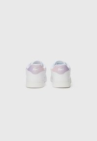 Hvite sneakers med en glatt lær-overdel, med en pastell-lilla aksent nær hælen, og en teksturert gummisåle.
