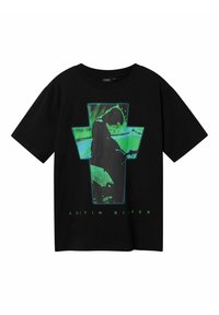 Sort bomulds t-shirt med et stort grønt grafisk design af en figur mod en korsform. Teksten nedenfor lyder "JUSTIN BIEBER."