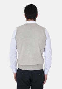 Gilet lavorato a maglia grigio chiaro con scollo rotondo, indossato sopra una camicia bianca con colletto. Presenta un fondo a costine e nessun motivo visibile.