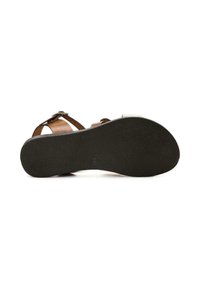 Sandal in pelle marrone con suola in gomma nera testurizzata. Presenta cinturini regolabili e un accento metallico. Design piatto per il massimo comfort.
