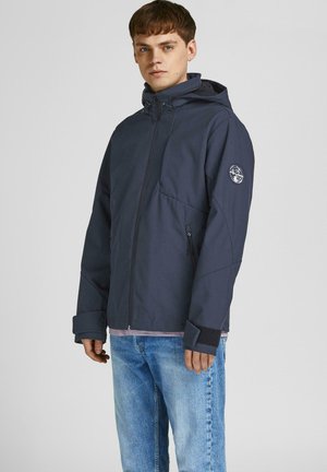 Navy blue waterproof jacket with a hood, zippered front, two side pockets, and elastic cuffs. Features a logo on the left sleeve.
