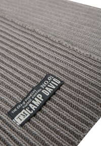 Gray, ribbed knitted fabric with a textured surface. Features a black label stating "CAMP DAVID" and other text. No visible patterns.