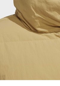 Gros plan de l'arrière du cou d'une doudoune beige avec un col relevé et rembourré.