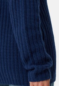 Maglione lavorato a maglia blu navy con un design a costine testurizzato, caratterizzato da una vestibilità ampia e polsini spessi. Realizzato in un materiale morbido simile alla lana.