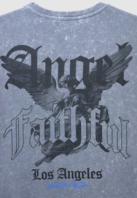 Illustrazione di un angelo con le ali e testo gotico "Angelo Fedele Los Angeles" su uno sfondo di tessuto grigio testurizzato.