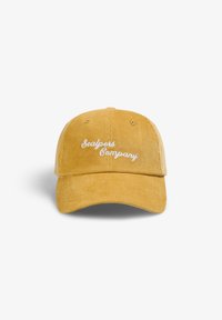 Gorra de béisbol de pana amarilla con bordado blanco "Scalpers Company" en la parte frontal. Presenta una visera curvada y una correa trasera ajustable.