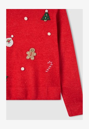 Maglione rosso lavorato a maglia con ricami a tema festivo: albero di Natale, Babbo Natale, omino di pan di zenzero, bastoncino di zucchero e pompon bianchi.