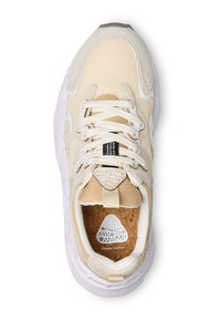 Beige Sneaker mit einer strukturierten Oberseite, weißer Gummisohle und einer Korkeinlage mit Blattmuster. Schnürsenkel und eine Schlaufe vervollständigen das Design.