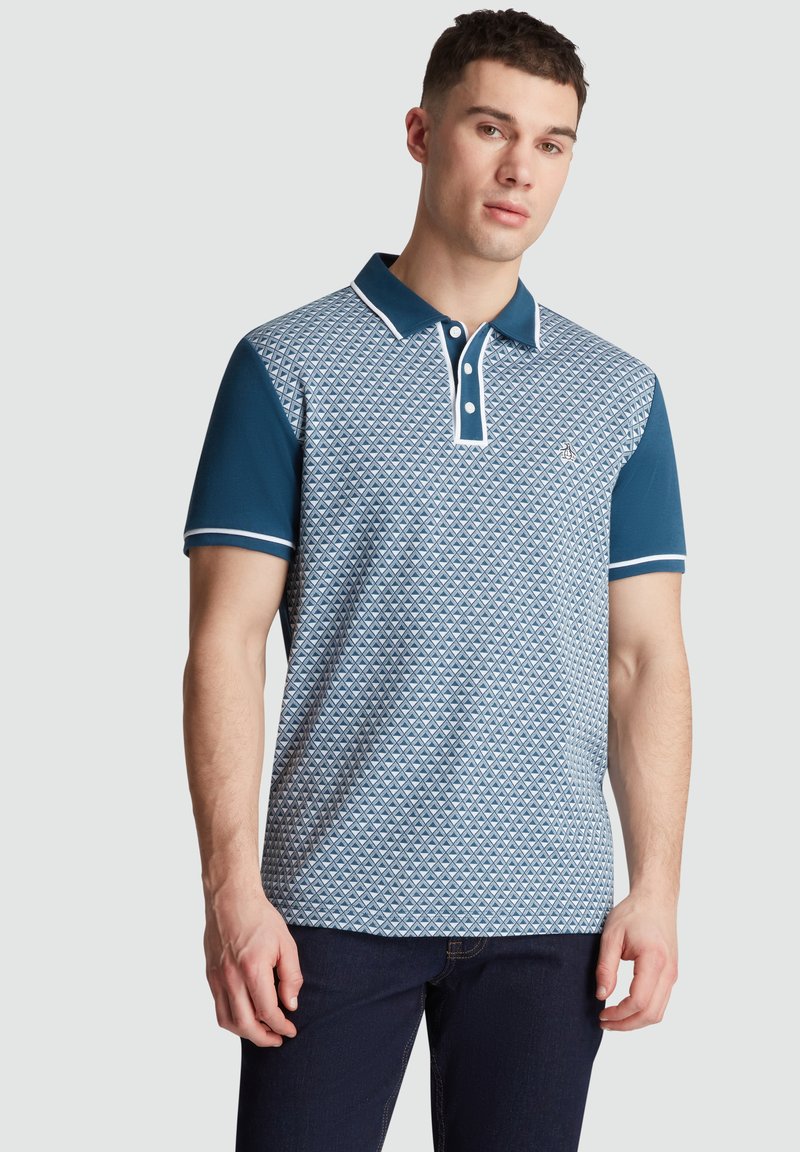 Polo à motif géométrique dans des tons de bleu, avec un col et des poignets bleu marine unis, et une patte de boutonnage à deux boutons.