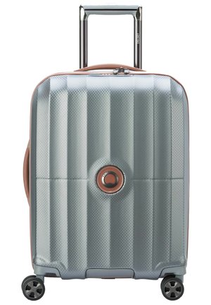Hard-shell suitcase with a silver textured surface, rose gold accents, extendable handle, and four black wheels for mobility.