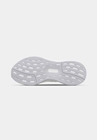 Hvit sneakersåle, teksturert gummi med et mønstret dekk for grep, og med hulskjæringer og en sentral spor-design.