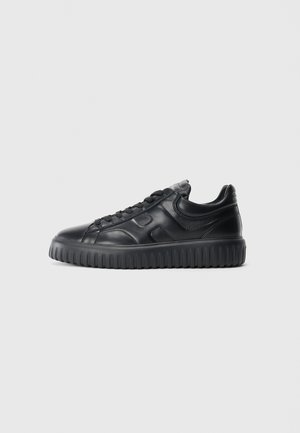 Black low-top leather sneaker with textured thick sole and lace-up closure, shown from the side on a plain light background.