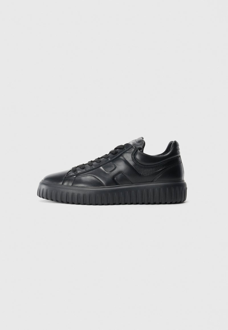 Black low-top leather sneaker with textured thick sole and lace-up closure, shown from the side on a plain light background.