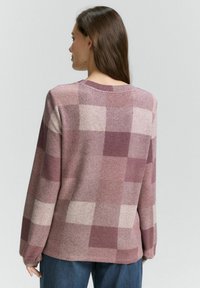 Maglione a quadri in tonalità di malva e rosa chiaro, con scollatura rotonda, maniche lunghe e un tessuto morbido e strutturato.