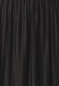 Gonna plissettata nera con superficie texture, caratterizzata da pieghe verticali che creano profondità e movimento. Tessuto liscio con una leggera lucentezza.