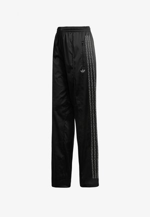 Pantaloni sportivi neri Adidas con fascia elastica in vita, tasca laterale con cerniera e tre strisce bianche punteggiate lungo i fianchi.