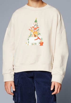 Enfant portant un sweat-shirt beige avec des animaux de la forêt empilés (ours, cerf, renard, manchot) formant une forme de sapin de Noël sur le devant.