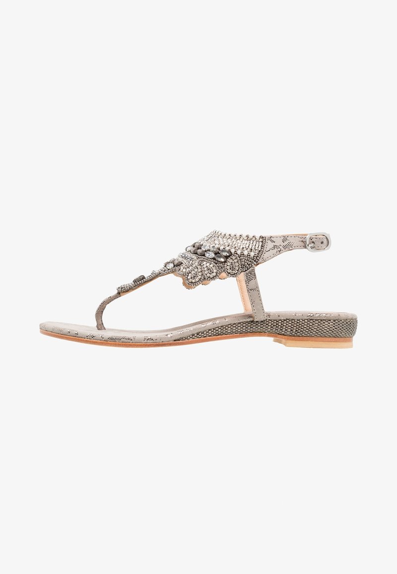 Metalliske sølv sandaler med dekorerede perler og sten, flad sål og justerbar ankelrem, med T-rem design.