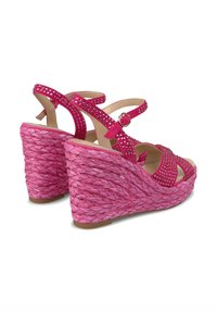 Sandali con tacco a cuneo rosa caratterizzati da tacco in corda intrecciata e cinturini decorati con strass. Cinturino alla caviglia regolabile per migliorare la vestibilità.