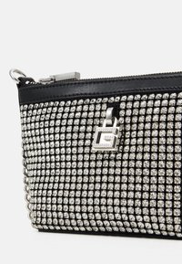 Czarna kopertówka z metalowymi akcentami, pokryta błyszczącymi cyrkoniami, z srebrnymi elementami i zapięciem na zamek.