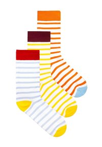 Trzy kolorowe skarpetki w paski ułożone jedna na drugiej, z czerwonymi, żółtymi i pomarańczowymi mankietami oraz dopasowanymi akcentami na palcach, na białym tle.