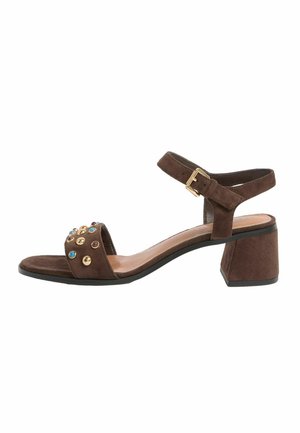 Brown suede sandal with block heel, ankle strap with gold buckle, and front strap adorned with gold and blue studs.